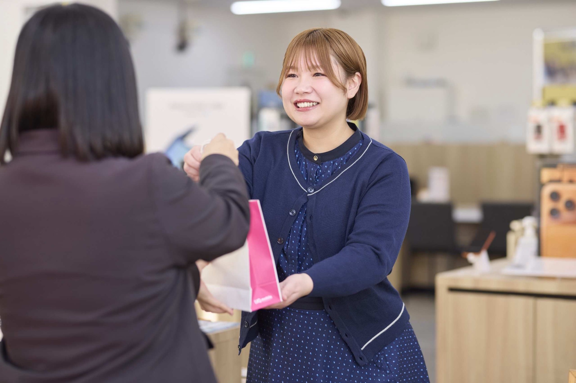 お客様に商品をお渡しするスタッフ