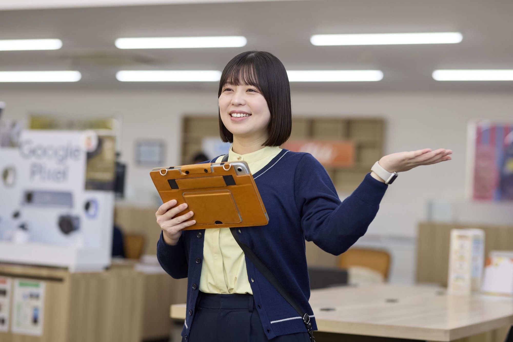 タブレットを手にご案内するスタッフ