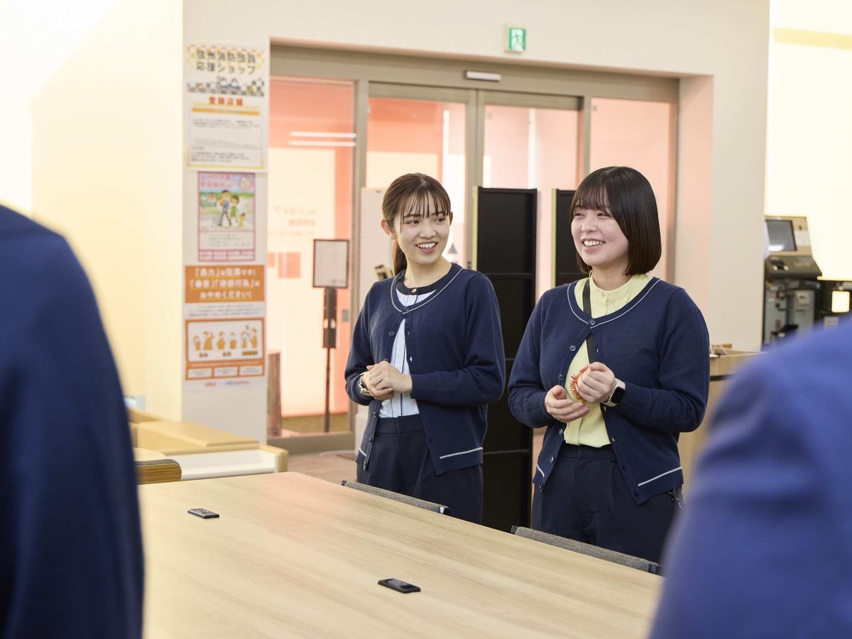 店内で話を聞く店舗スタッフ2人